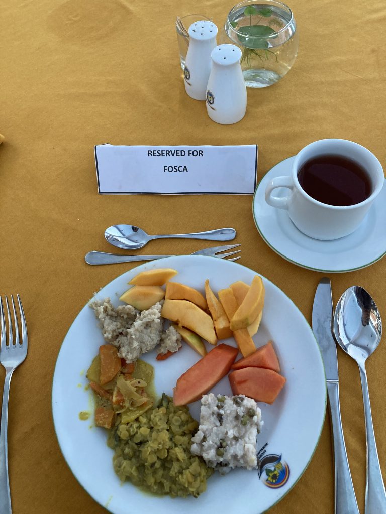 Piatto con riso e lenticchie, porridge e frutta tropica e una tazza di tè