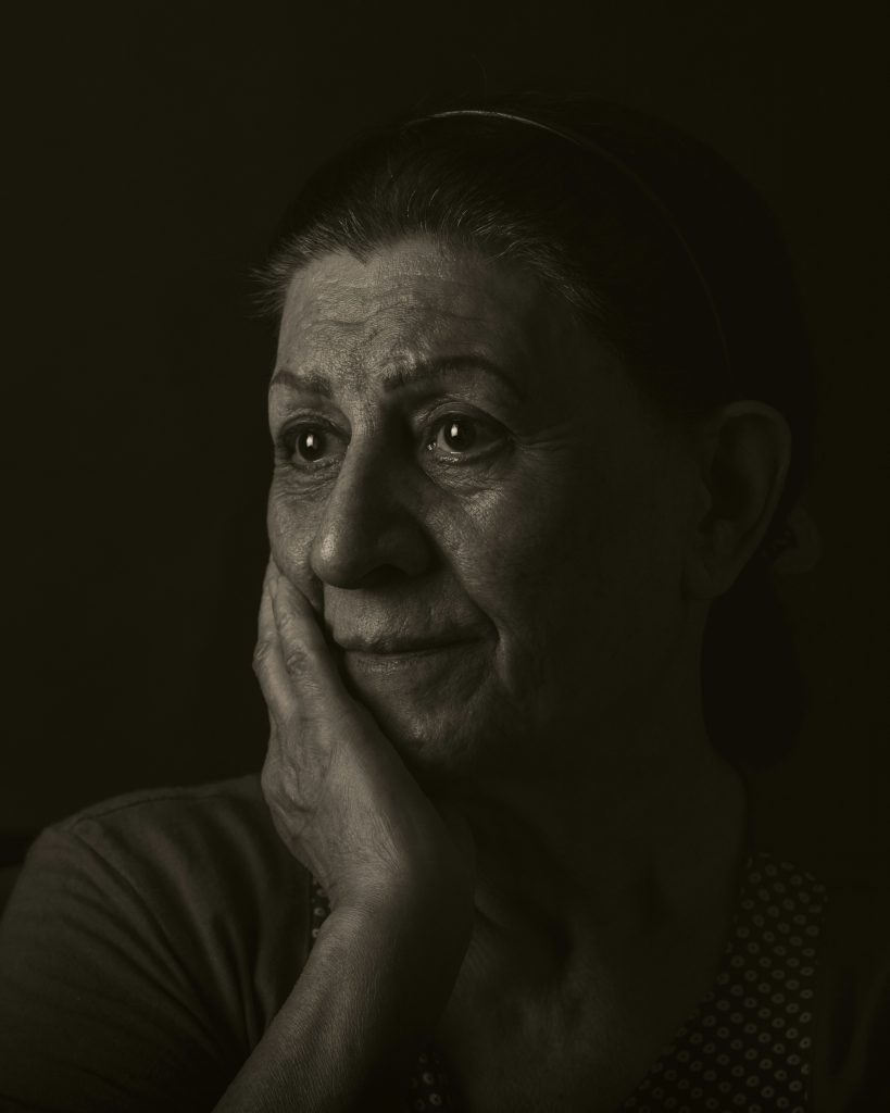 Donna over 50 sola al buio con sguardo triste e affaticato