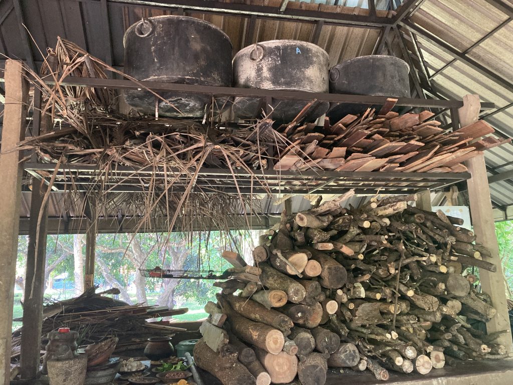 Mucchi di legna e pentoloni per preparare l'olio per i massaggi