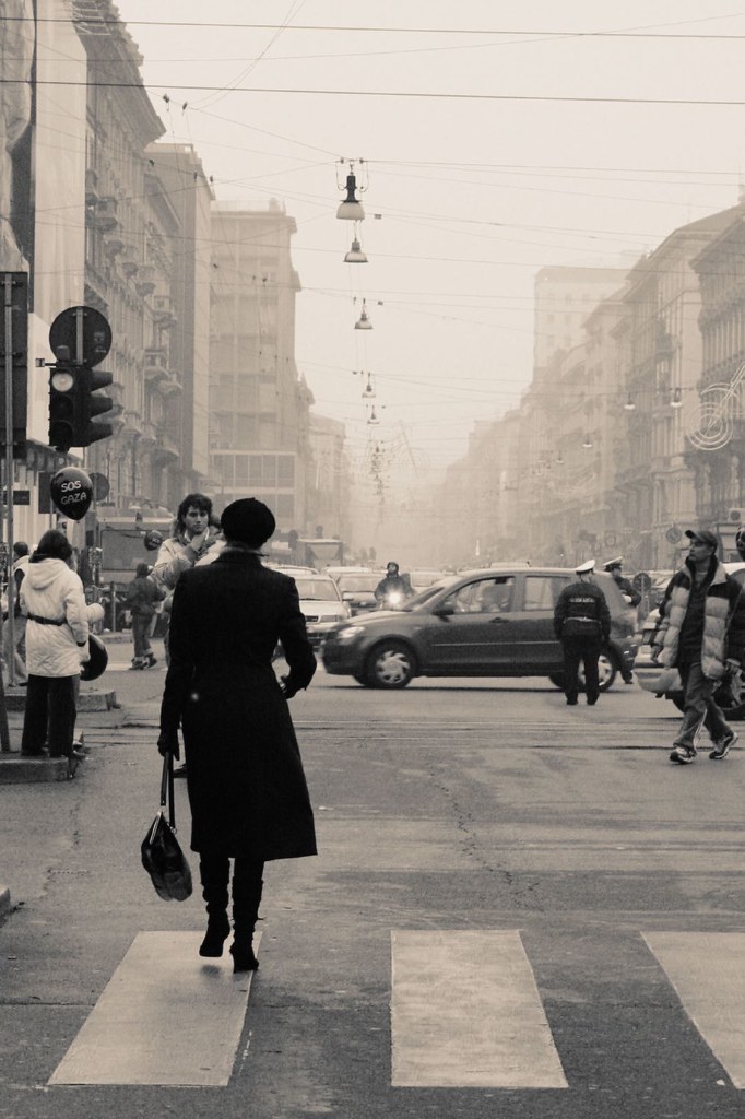 Una donna di spalle che cammina in città, in bianco e nero ,a 25 anni come a 40
