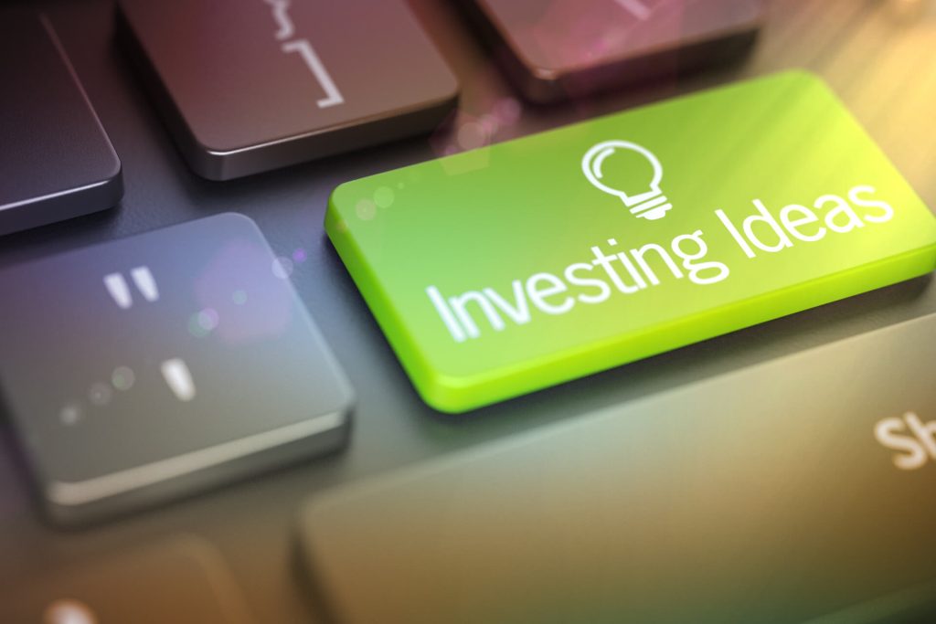 Una tastiera di un laptop con un tasto verde con scritto Investing ideas e il simbolo della lampadina