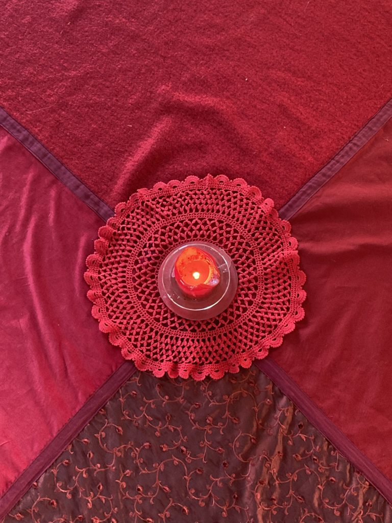 Telo rosso con 4 spicchi diversi e una candela al centro